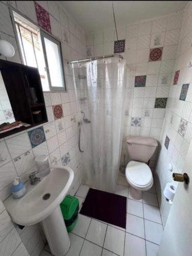 a bathroom with a sink and a toilet and a shower at Cabaña a pasos del Faro De La Serena in La Serena