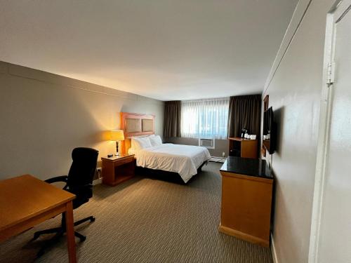 um quarto de hotel com uma cama e uma secretária em Anavada Inn & Suites - Prince George em Prince George