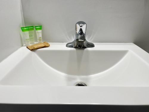 a bathroom sink with a faucet and two soap bottles at Anavada Inn & Suites - Prince George in Prince George
