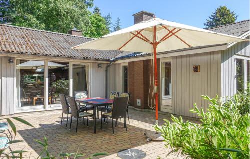 a patio with a table and chairs and an umbrella at 3 Bedroom Lovely Home In Rnne in Rønne