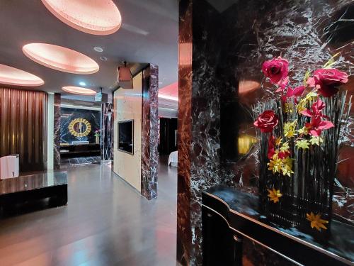 a lobby with a vase of flowers on a wall at Elysees Motel in Toufen