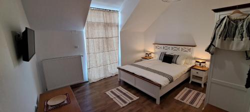 a small bedroom with a bed and a window at Porumbacu381 - Casa de Oaspeti Faini in Porumbacu de Sus