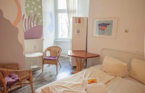 a bedroom with a bed and a table and chairs at BackpackerBerlin in Berlin