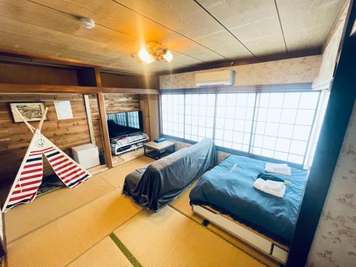 伊豆市にあるRyokan La Lunaのベッド1台とハンモックが備わる客室です。