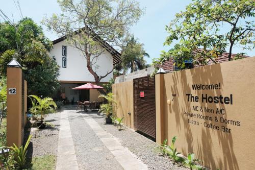 a sign on a fence next to a house at The Hostel in Mirissa