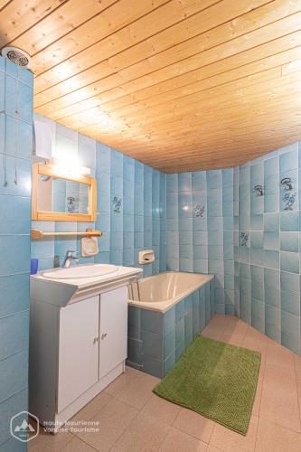 La salle de bains bleue est pourvue d'une baignoire et d'un lavabo. dans l'établissement AGNELIE 4, à Bonneval-sur-Arc