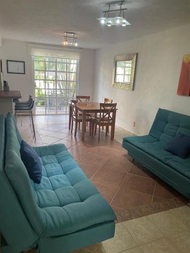 a living room with a blue couch and a table at Renta de departamento en Acapulco Diamante in Acapulco