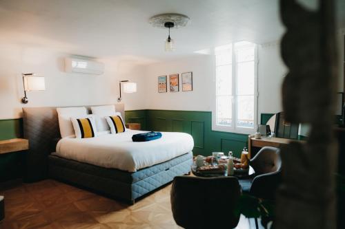 a bedroom with a bed and a table at La Belle Endormie B&B French Guest house in Bordeaux