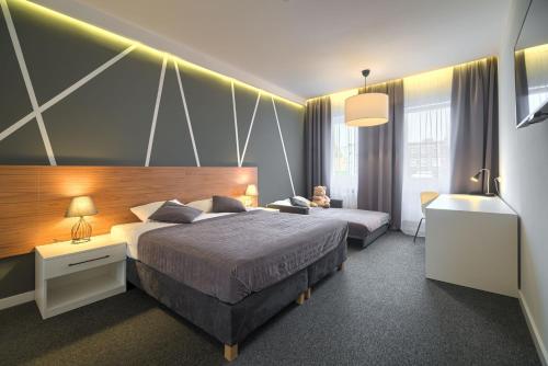 a hotel room with two beds and a desk at Park Hotel Bydgoszcz in Bydgoszcz