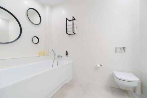 a white bathroom with a toilet and a mirror at Park Hotel Bydgoszcz in Bydgoszcz