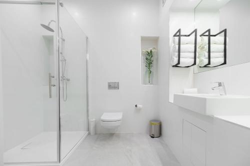 a white bathroom with a shower and a toilet at Park Hotel Bydgoszcz in Bydgoszcz