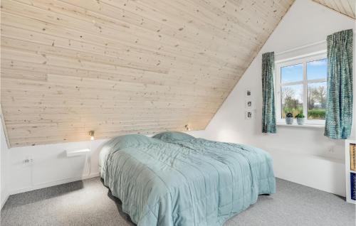 1 dormitorio con 1 cama y pared de madera en Nice Home In rskbing With Kitchen, en Ærøskøbing