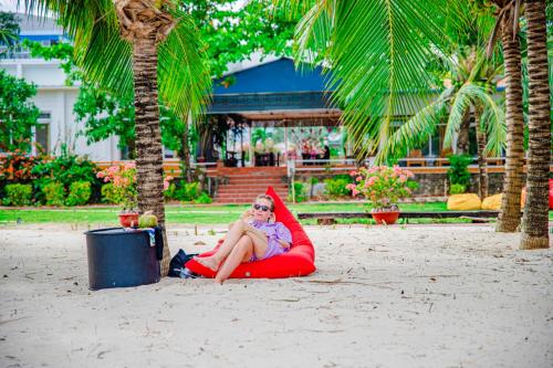 a woman sitting on a red raft on a beach at Thiên Tân Hotel in Con Dao