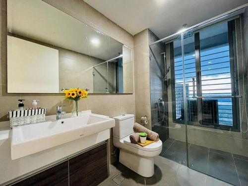 uma casa de banho com um WC, um lavatório e um chuveiro em Teega Suites by Antlerzone em Nusajaya