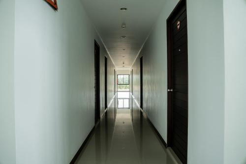 a hallway with white walls and black doors at Circle Inn Ao Nam Mao in Ao Nam Mao