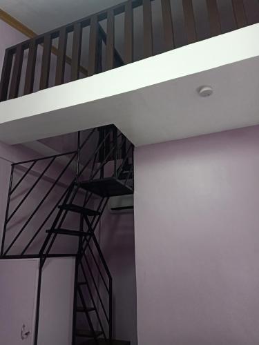 a spiral staircase in a room with a white ceiling at Stella'z guesthouse in Siquijor