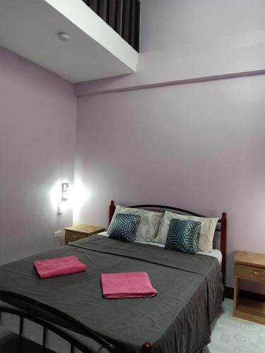 a bedroom with a bed with two pink towels on it at Stella'z guesthouse in Siquijor