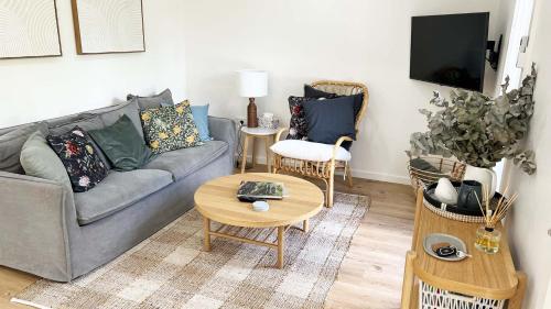 a living room with a couch and a table at Honey Fig Cottage, Bowral in Bowral