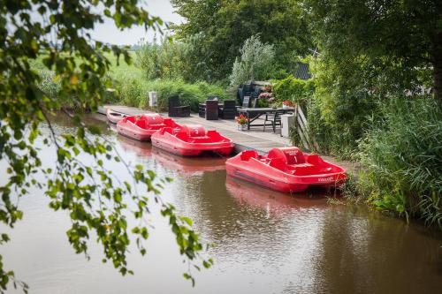a group of red boats sitting in the water at Farm Overleekerhoeve in Monnickendam
