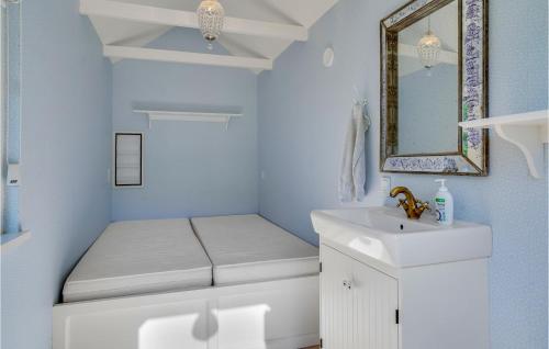 La salle de bains est pourvue de toilettes, d'un lavabo et d'un miroir. dans l'établissement Cozy Home In Hornbk With Kitchen, à Hornbæk