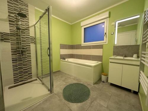 een badkamer met een douche, een bad en een wastafel bij gîte neuf proche de la plage in Oye-Plage
