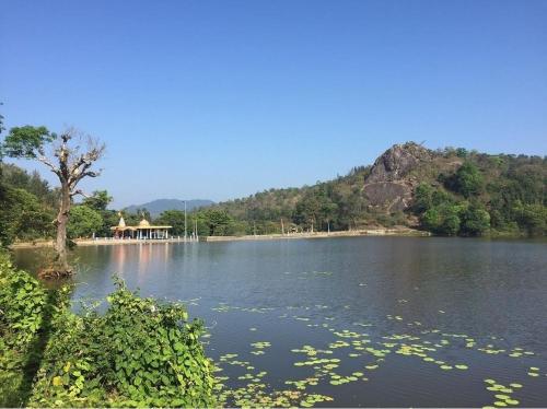 a lake with a house in the middle of it at Little bungalow Holiday Home, Coorg in Somvārpet