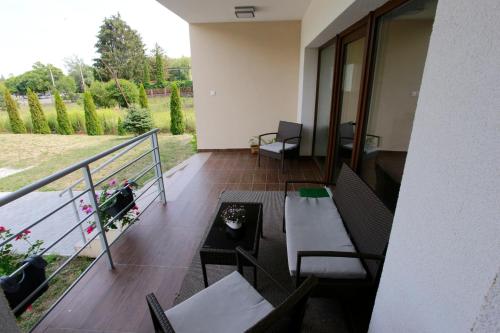a balcony with chairs and a table with a view of a yard at Villa Terrasse in Eger