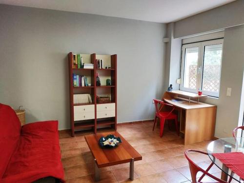 a living room with a red couch and a desk at Heraklion modern studio 40 sq.m. near town center. in Heraklio