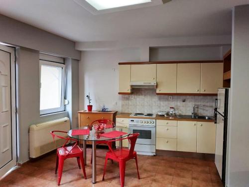 a kitchen with a table and two red chairs at Heraklion modern studio 40 sq.m. near town center. in Heraklio