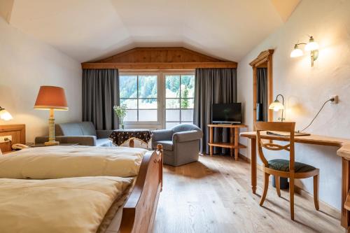 a hotel room with two beds and a living room at Naturhotel Lärchenhof in Mittelberg