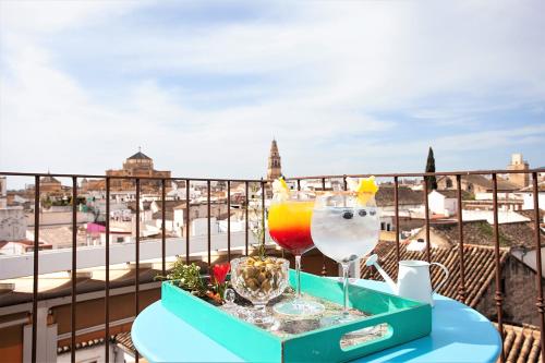 ein Tablett mit zwei Getränken auf dem Tisch auf dem Balkon in der Unterkunft Hotel Madinat in Córdoba