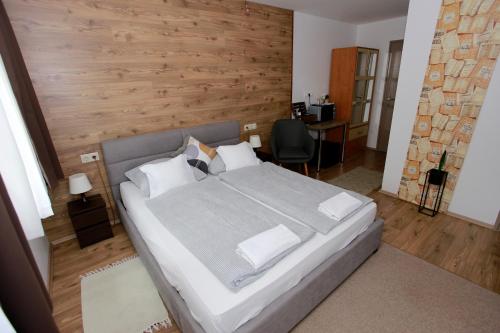 a bedroom with a large bed with a wooden wall at Villa Terrasse in Eger