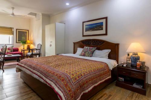 a bedroom with a bed and a chair and a table at Neelam Bed & Breakfast in Kolkata