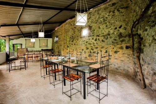 Cette grande chambre comprend une table et des chaises. dans l'établissement River Edge Eco Resort, à Kitulgala