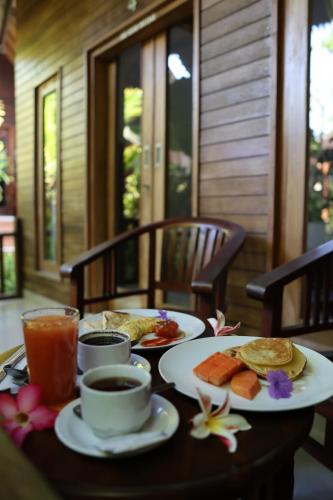 een tafel met borden met eten en drinken erop bij The Catar Cottages in Nusa Penida