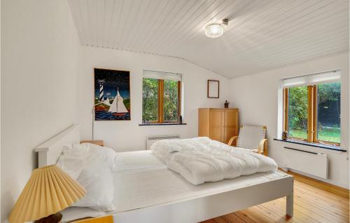 a white bedroom with a large white bed and windows at Beautiful Home In Slagelse With House Sea View in Slagelse