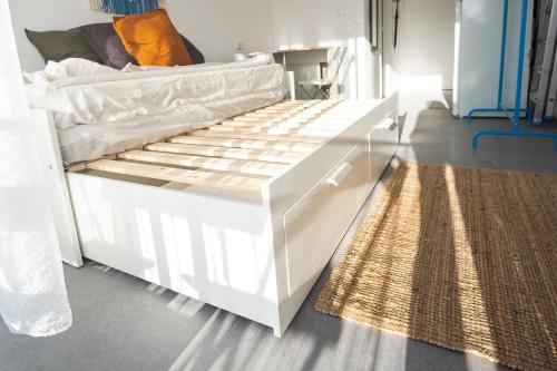a white bed in a room with a rug at Casa Carmelina in Torrevieja