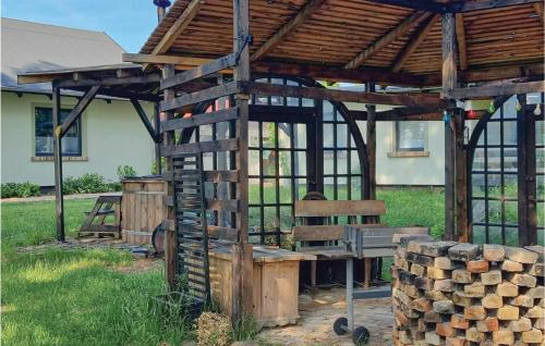 a wooden shelter with a bench and a pile of logs at Gorgeous Home In Wilcze With Wifi in Wilcze