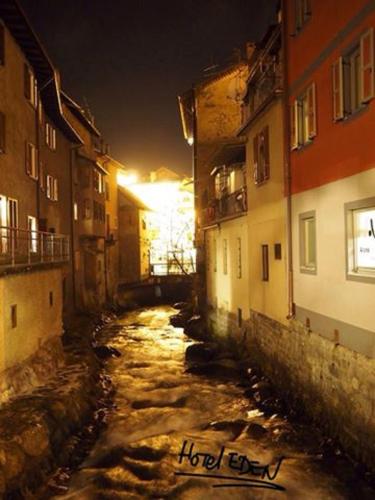 an alley with snow and buildings in a city at night at Albergo Eden in Ponte di Legno