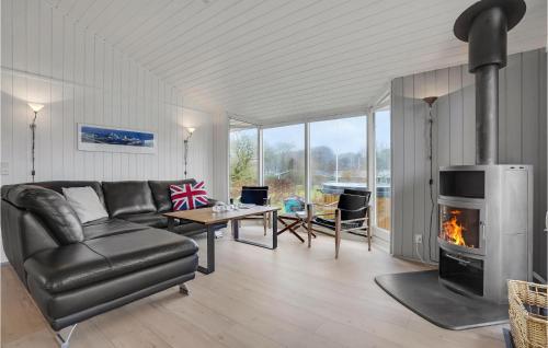 una sala de estar con un sofá y una chimenea en Three-Bedroom Holiday Home In Haderslev, en Sønderballe