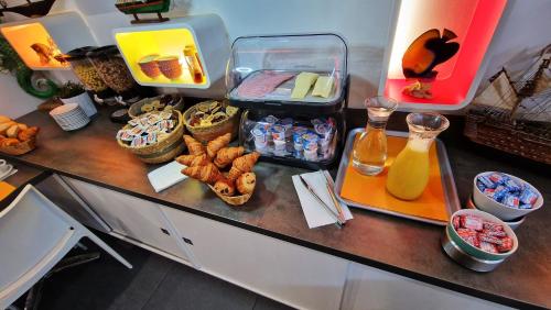 a counter with food and drinks and snacks on it at Hôtel Au Valéry in Sète