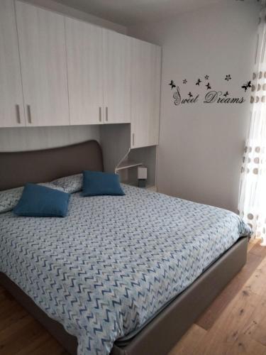 sypialnia z dużym łóżkiem z niebieskimi poduszkami w obiekcie Condominio Baradello w mieście Aprica