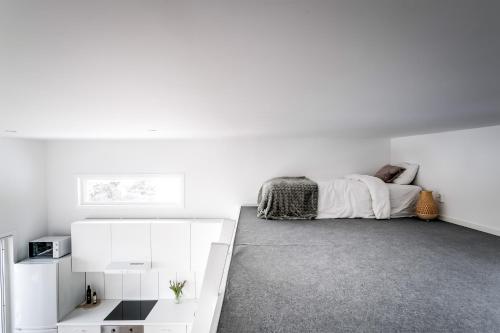 a white bedroom with a bed and white cabinets at New lakehouse - amazing sea view and private pier! in Stockholm