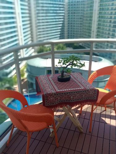 a table and chairs on a balcony with a plant on it at Holiday Escape Philippines in Manila