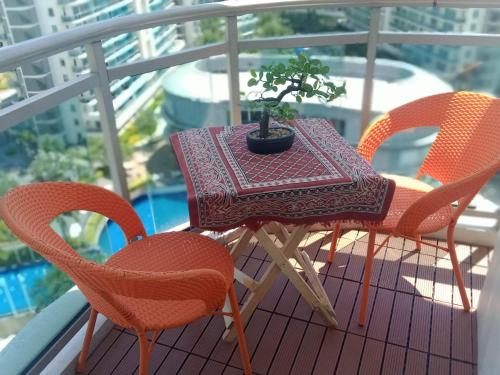 a table and chairs with a plant on a balcony at Holiday Escape Philippines in Manila