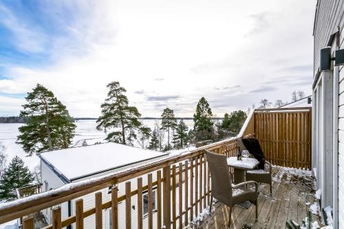 a balcony with a table and chairs and snow covered trees at New lakehouse - amazing sea view and private pier! in Stockholm