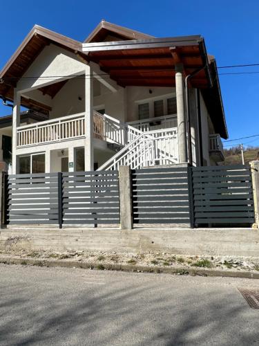 a large white house with a porch and stairs at House in beautiful nature in Pazarić