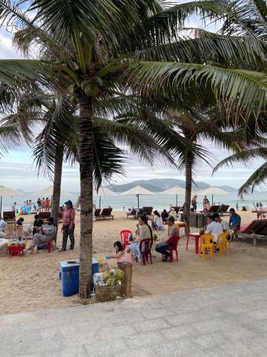 a group of people sitting in chairs on the beach at Tokia hotel nha trang in Nha Trang