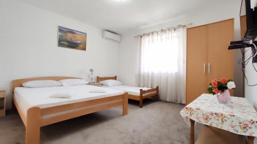 een hotelkamer met 2 bedden en een raam bij Apartment in nature in Bijela
