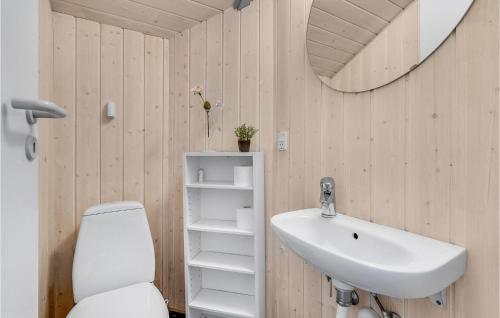 een badkamer met een wastafel, een toilet en een spiegel bij 4 Bedroom Lovely Home In Vggerlse in Bøtø By